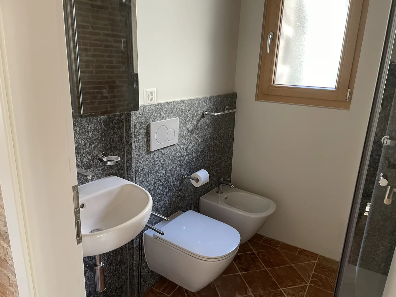 Bagno della zona giorno con lavabo e rivestimento in pietra